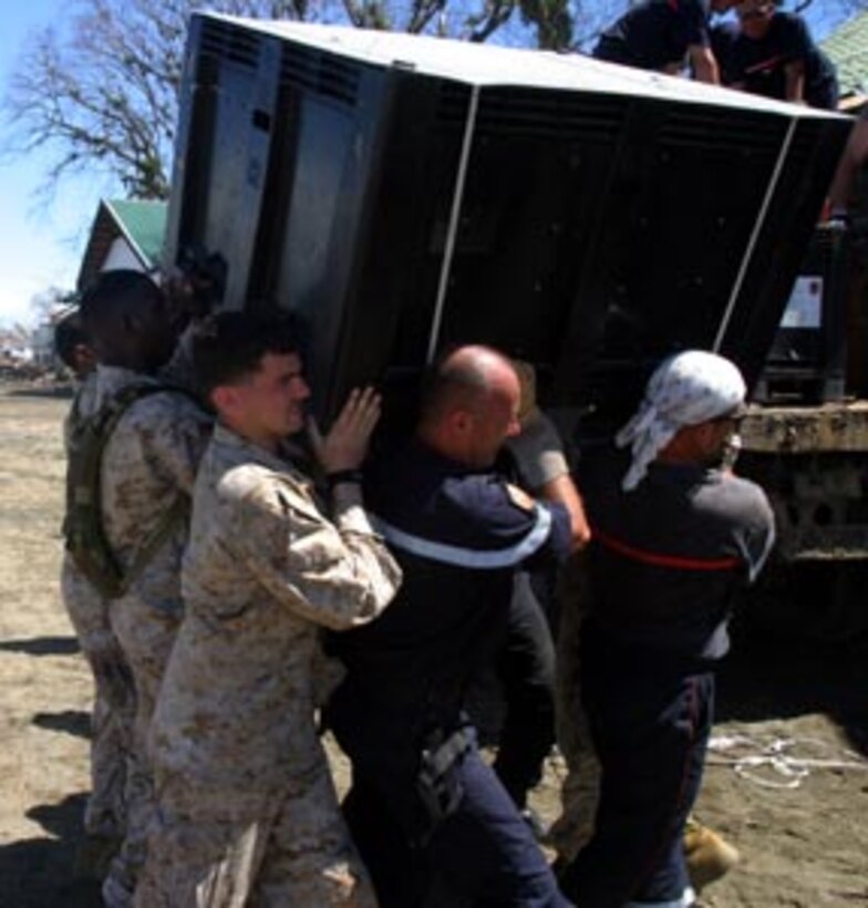 Marines and sailors with the 15th Marine Expeditionary Unit (Special Operations Capable) teamed up with French service members while loading humanitarian aid supplies into the back of a utility vehicle that were to be distributed to victims of the recent tsunami.