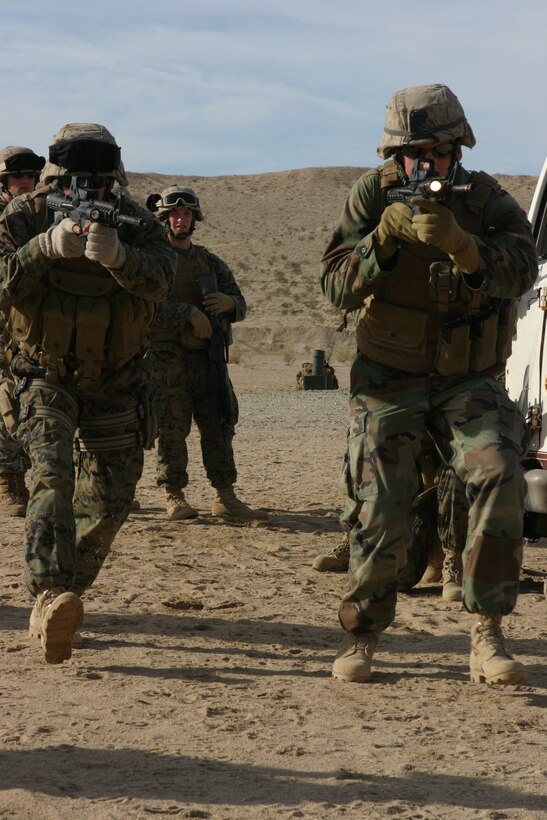 050116-M-4224F-002 MARINE CORPS AIR GROUND COMBAT TRAINING CENTER TWENTY-NINE PALMS,Calif.- Cpl. Karl Schaffer (left) and Cpl. Daniel C. Lockridge (right), scout snipers with the sniper platoon of Weapons Company, 3rd Battalion, 2d Marine Regiment charge a building during the Combined Arms Exercise. The training was the last opportunity for these Marines to prepare for deployment to Iraq. U.S. Marine Corps photo by Lance Cpl. Lucian Friel (RELEASED)