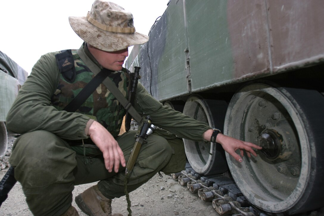 MARINE CORPS BASE CAMP LEJEUNE, N.C. (Feb. 14, 2004) - Lance Cpl. John. O. Young, a Nampa, Idaho native, and tank driver checks the track oil as part of the tank maintenance on his M1-A1 Abrams Tank during a field operation here recently. Young and 27 other Marine reservists, formerly from Company C, 4th Tank Battalion stationed in Boise, were recently activated and are currently in attached to 2nd Tank Battalion preparing to deploy in support of Operation Iraqi Freedom.