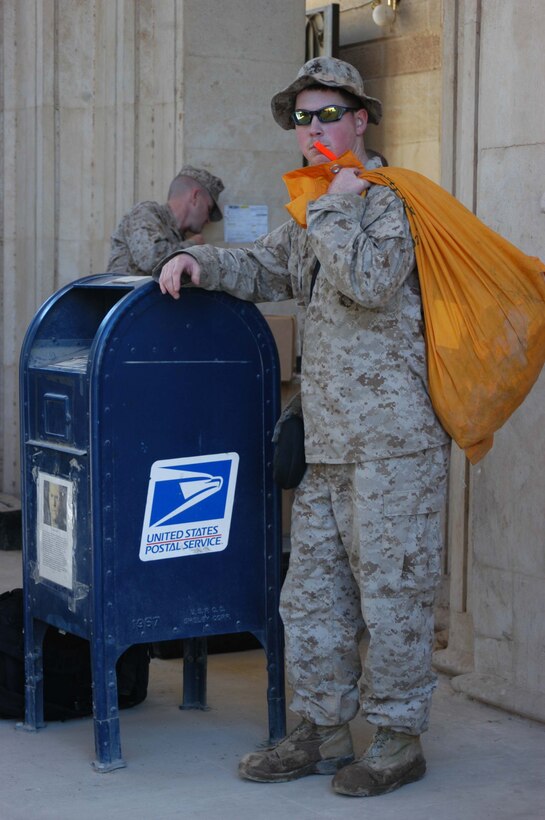 CAMP BLUE DIAMOND, Ar Ramadi, Iraq (March 14, 2005) -- Lance Cpl. Richard E. Beland, mail clerk for 1st Battalion, 5th Marine Regiment, waits outside the post office here with mail for Marines at Hurricane Point. The 22-year-old from Garner, N.C., makes mail runs here two and three times a week in a 7-Ton truck. Convoys have suffered numerous attacks from improvised explosive devices on the route between Hurricane Point and Camp Blue Diamond. The 2000 Garner Senior High School graduate is responsible for collecting, sorting and distributing mail to the more than 900 Marines in the infantry battalion. (Photo by Cpl. Tom Sloan)