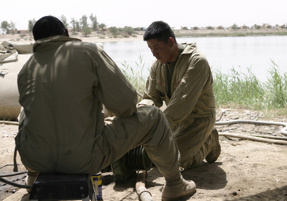 CAMP BAHARIA, Iraq - Cpl. Harold Joe, hygiene equipment operator with 8th Engineer Support Battalion, II Marine Expeditionary Force and Window Rock, Ariz. native, right, works with a fellow Marine to repair components to a Reverse Osmosis Water Purification Unit here May 1.  Joe and his teammates are responsible for providing several military camps in the area with water by pumping and purifying tens of thousands of gallons everyday from the manmade lake here.