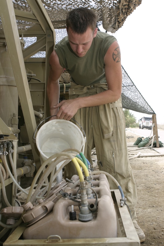 CAMP BAHARIA, Iraq - Cpl. Nathan Hoin, hygiene equipment operator with 8th Engineer Support Battalion, II Marine Expeditionary Force and 21-year-old Kissimmee, Fla. native, pours chlorine into a Reverse Osmosis Water Purification Unit here May 1.  Hoin and his teammates are responsible for providing several military camps in the area with water by pumping and purifying tens of thousands of gallons everyday from the manmade lake here.