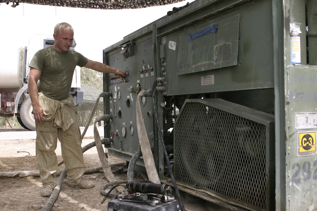 CAMP BAHARIA, Iraq - Sgt. Wesley Webb, hygiene equipment operator with 8th Engineer Support Battalion, II Marine Expeditionary Force and Hinton, Iowa native, checks a Reverse Osmosis Water Purification Unit here May 1 to ensure it works properly.  Webb and his teammates are responsible for providing several military camps in the area with water by pumping and purifying tens of thousands of gallons everyday from the manmade lake here.