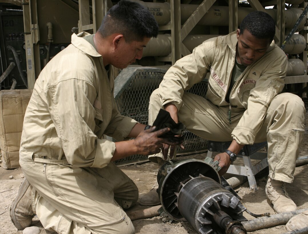 CAMP BAHARIA, Iraq - Cpl. Harold Joe, hygiene equipment operator with 8th Engineer Support Battalion, II Marine Expeditionary Force and Window Rock, Ariz. native, left, and Lance Cpl. Dane Elleson, electrician with the 8th ESB and Plantation, Fla. native, attempt to fix components to a Reverse Osmosis Water Purification Unit here May 1.  The Marines are responsible for providing several military camps in the area with water by pumping and purifying tens of thousands of gallons everyday from the manmade lake here.