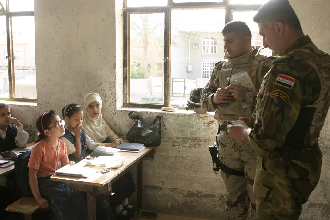 FALLUJAH, Iraq - Iraqi Maj. Laith Jabbar Al Tememey, company commander for 1st Company, 1st Battalion, 2nd Brigade, Iraqi Security Forces, right, and Iraqi Maj. Muhammad-Hasan Hasan Fuaad, executive officer for 1st Battalion, 2nd Brigade, ISF, interact with a schoolchildren shortly after hanging up a new chalkboard inside their school here May 2.  ISF and Marines here visited local schools to distribute blackboards, school desks, and writing supplies as part of the ongoing joint civil-military mission, "Operation Blackboard."