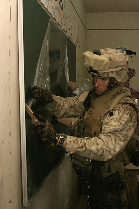 FALLUJAH, Iraq - 1st Lt. Thomas Waller, executive officer for Company B, 1st Battalion, 6th Marine Regiment, slices the protective plastic covering off of a new chalkboard inside a school here May 2.  Iraqi Security Forces and Marines here visited local schools to distribute blackboards, school desks, and writing supplies as part of the ongoing joint civil-military mission, "Operation Blackboard."