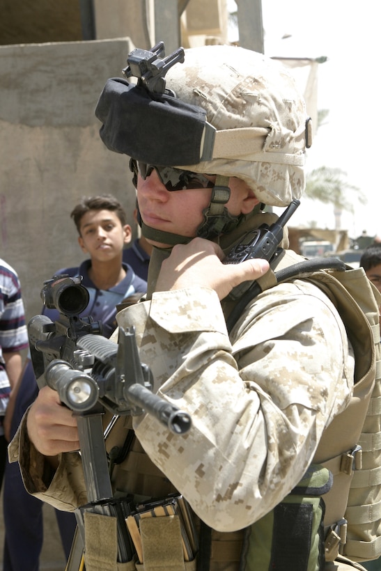 FALLUJAH, Iraq - Lance Cpl. Brad McKee, an assaultman with 1st Squad, 2nd Platoon, Company B, 1st Battalion, 6th Marine Regiment, provides security outside a local school May 4 while fellow Marines and Iraqi soldiers distribute chalkboards inside.  Iraqi Security Forces and Marines here visited local schools to distribute blackboards, school desks, and writing supplies as part of the ongoing joint civil-military mission, "Operation Blackboard."