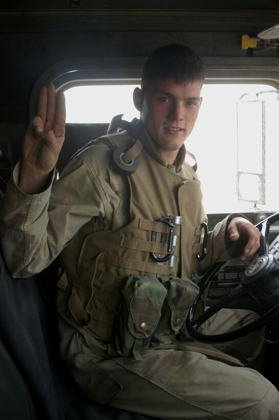 CAMP RAMADI, Iraq (May 6, 2005) -Sitting behind the wheel of his 7-ton truck, Lance Cpl. Mathew D. Hawkins, a motor transportation operator with Truck Company, Headquarters Battalion, 1st Marine Division, gives the Scout's Honor sign. Hawkins, 21, of Chicago is also an Eagle Scout. The 2003 Crandon High School graduate joined the Cub Scouts at the age of eight and was an active member for nine years during which time he earned 32 merit badges. The Operation Iraqi Freedom II veteran drives in a re-supply convoy and is responsible for keeping 1st Battalion, 5th Marine Regiment's firm bases, Camp Snake Pit and Hurricane Point supplied with fuel. Photo by Cpl. Tom Sloan