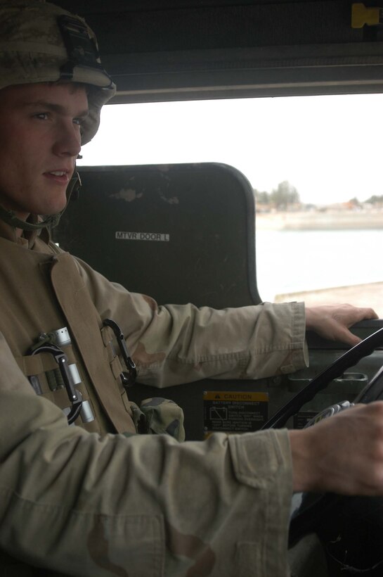AR RAMADI, Iraq (May 6, 2005) -Sitting behind the wheel of his 7-ton truck, Lance Cpl. Mathew D. Hawkins, a motor transportation operator with Truck Company, Headquarters Battalion, 1st Marine Division, drives along a city street here on a re-supply mission. Hawkins, 21, of Chicago is also an Eagle Scout. The 2003 Crandon High School graduate joined the Cub Scouts at the age of eight and was an active member for nine years during which time he earned 32 merit badges. The Operation Iraqi Freedom II veteran drives in a re-supply convoy and is responsible for keeping 1st Battalion, 5th Marine Regiment's firm bases, Camp Snake Pit and Hurricane Point supplied with fuel. Photo by Cpl. Tom Sloan