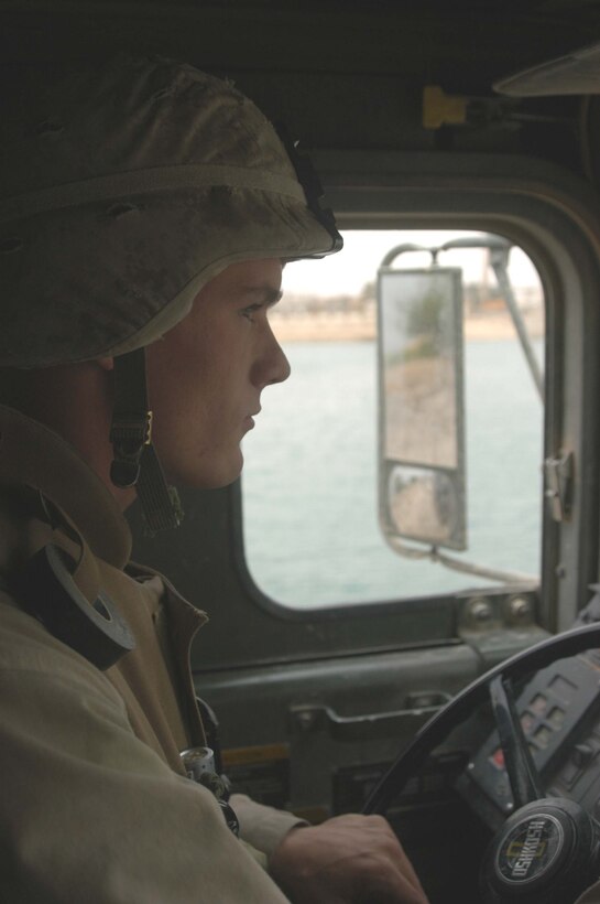 AR RAMADI, Iraq (May 6, 2005) -Sitting behind the wheel of his 7-ton truck, Lance Cpl. Mathew D. Hawkins, a motor transportation operator with Truck Company, Headquarters Battalion, 1st Marine Division, drives along a city street here on a re-supply mission. Hawkins, 21, of Chicago is also an Eagle Scout. The 2003 Crandon High School graduate joined the Cub Scouts at the age of eight and was an active member for nine years during which time he earned 32 merit badges. The Operation Iraqi Freedom II veteran drives in a re-supply convoy and is responsible for keeping 1st Battalion, 5th Marine Regiment's firm bases, Camp Snake Pit and Hurricane Point supplied with fuel. Photo by Cpl. Tom Sloan