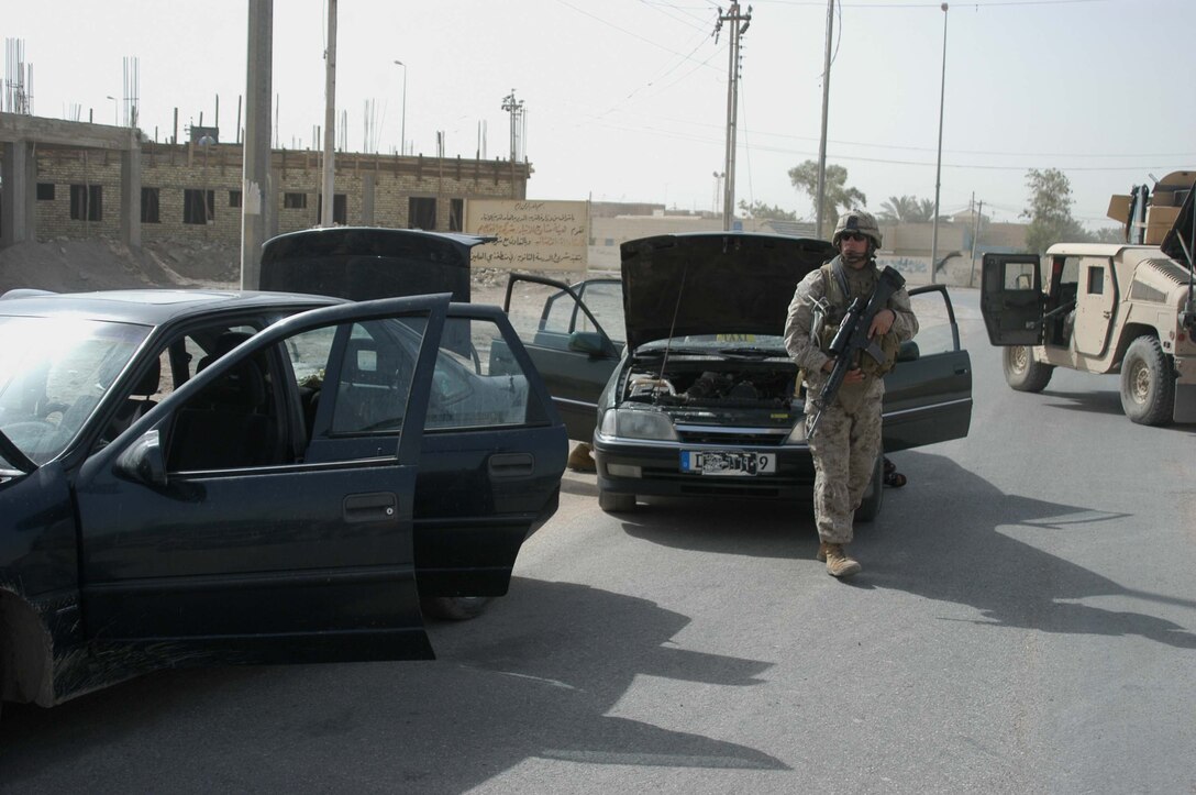 AR RAMADI Iraq (July 16, 2005) - Lance Cpl. Tony Leal, a rifleman and team leader with 3rd Squad, 4th Platoon, Company A, 1st Battalion, 5th Marine Regiment, secures a street in the Al Anbar capital city so other Marines can searched vehicles during Operation Fire, which was conducted July 14. The 24-year-old from Staford, Texas, and other Marines with the Camp Pendleton, Calif., based infantry battalion stopped traffic in various parts of the city and conducted vehicle and personnel searches during the three-hour operation, which netted the capture of seven insurgents. Photo by: Cpl. Tom Sloan