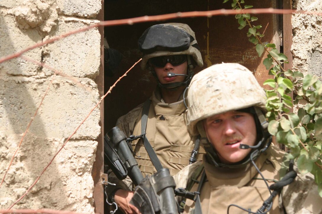 CAMP BLUE DIAMOND, AR RAMADI, Iraq - Corporal William Martinez, 3rd Platoon squad leader and 21-year-old Peakskill, N.Y. native talks over his headset radio to other members of his team while on patrol in the area outside the wall, Aug. 14.  U.S. Marine Corps photo by Sgt. Stephen D'Alessio (RELEASED)