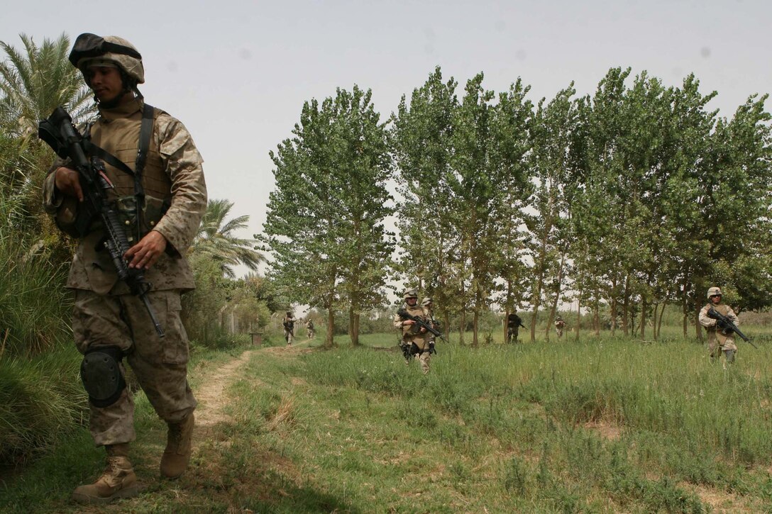 CAMP BLUE DIAMOND, AR RAMADI, Iraq - Members of the guard force here patrol the area outside the wall, Aug. 14.  U.S. Marine Corps photo by Sgt. Stephen D'Alessio (RELEASED)