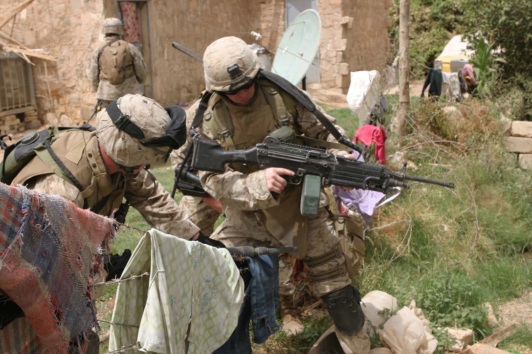 CAMP BLUE DIAMOND, AR RAMADI, Iraq - Members of the guard force here straddle a barbed wire fence while on patrol in the area outside the wall, Aug. 14.  U.S. Marine Corps photo by Sgt. Stephen D'Alessio (RELEASED)