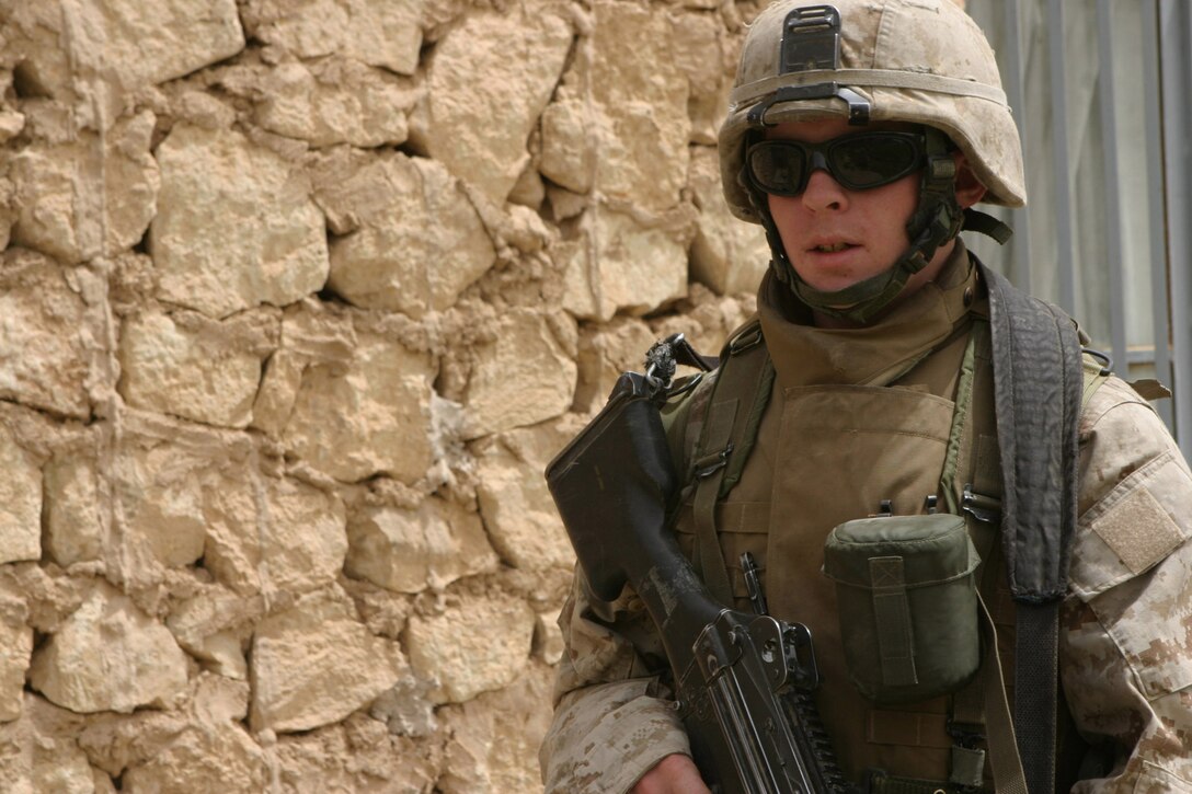 CAMP BLUE DIAMOND, AR RAMADI, Iraq - Corporal William Bryan Malin, a Squad Automatic Weapon machine gunner with the camp's guard force revels in his ability to be able to do something positive for the children here.  For the past six months, the 20-year-old Colorado Springs, Colo. native and his squad have been patrolling through the farm lands and villages that cushion the outside walls of the camp.  The children know who he is, because they usually get a little teddy bear when he passes through their field.  U.S. Marine Corps photo by Sgt. Stephen D'Alessio (RELEASED)