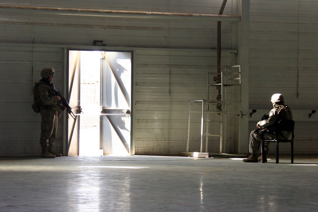 AR RAMADI, Iraq (Oct. 14, 2005) - Two Marines from Company K, 3rd Battalion, 7th Marine Regiment, guard the door of one of the election sites in preparation of the national constitutional referendum vote held Oct. 15. Photo by Cpl. Shane Suzuki