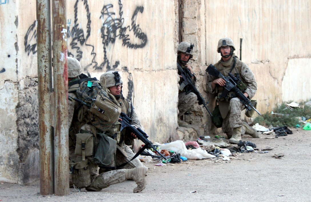 AR RAMADI, Iraq (Oct. 14, 2005) - Four Marines from Company K, 3rd Battalion, 7th Marine Regiment, take security position while patrolling through the city on their way to one of the constitutional referendum polling sites Oct. 14. Photo by Cpl. Shane Suzuki