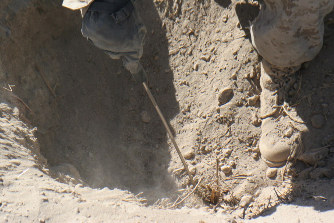 051114-M-2607O-005 - Sergeant Chad T. Johnson, combat engineer with 2nd Battalion, 2nd Marine Regiment, probes the hole he dug for metal further down while searching for weapons caches Nov. 14, during Operation TRIFECTA.