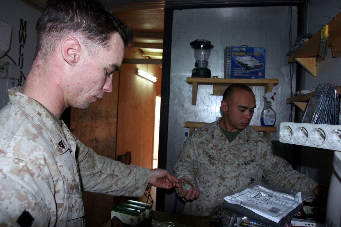 AR RAMADI, Iraq ? Lance Cpl. Christopher Hunt runs the register at the Marine Corps Exchange. The exchange, which has a variety of goods for sale, is just a way to bring a little bit of home to these Marines, said Hunt.