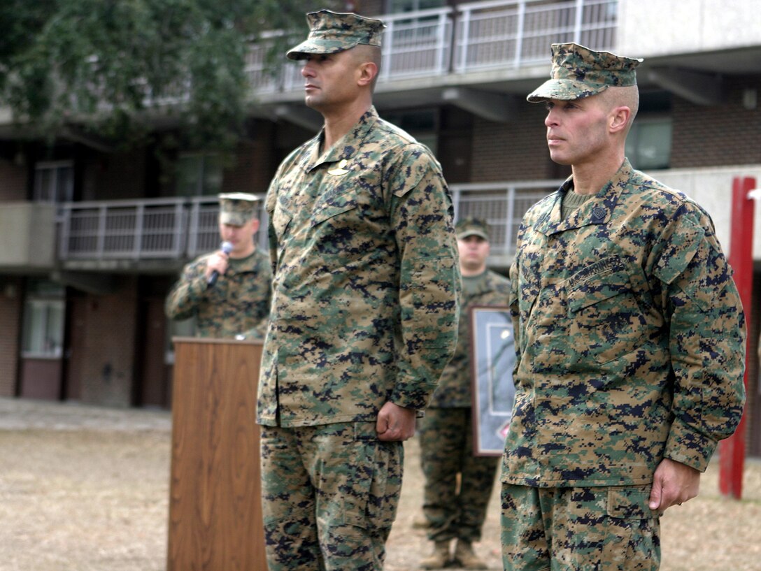 MARINE CORPS BASE CAMP LEJEUNE, N.C. - Sergeant Major T.F. Hall, right, and 1st Sgt. Ernest Hoopii, left, stand side-by-side here Dec. 14 during a 1st Battalion, 6th Marine Regiment's post and relief ceremony.  Hall, a veteran of Operations Enduring Freedom and Iraqi Freedom, was relieved as battalion sergeant major by 1st Sgt. Ernest Hoopii.  Hall is currently 2nd Assault Amphibian Battalion's sergeant major.