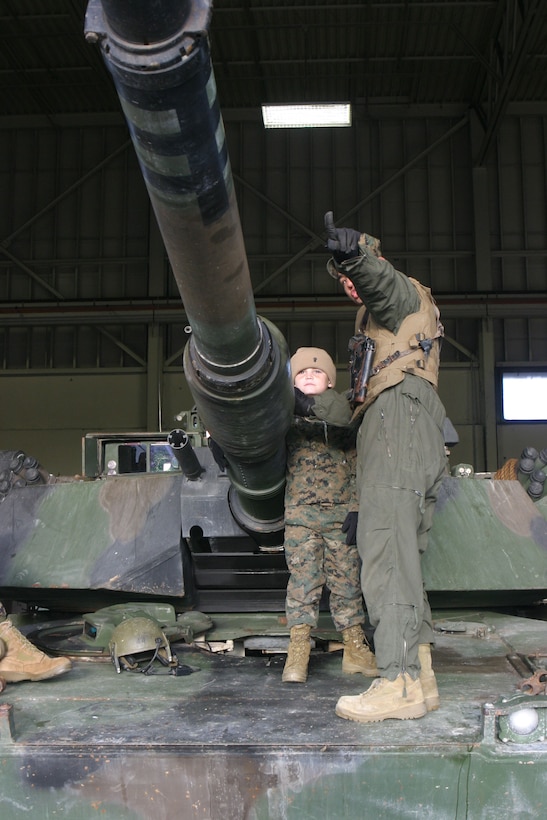 MARINE CORPS BASE CAMP LEJEUNE, N.C. (Dec. 14, 2005)- Sgt. Ricardo Fernandez Jr., a tank commander with 2nd Tank Battalion, 2nd Marine Division shows 6-year-old Brandon Rasnick the capabilities of the tank main gun. Brandon made a wish to train with Marines and save the world and that wish came true. (Official U.S. Marine Corps photo by Lance Cpl. Lucian Friel (RELEASED)