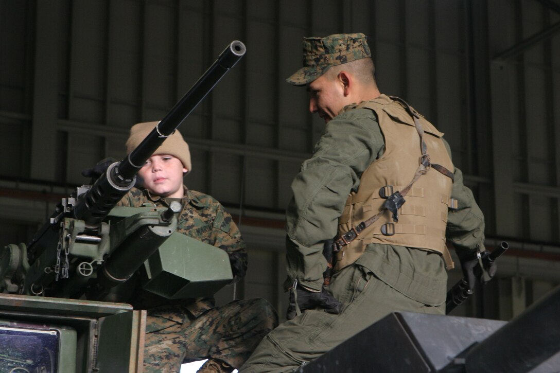 MARINE CORPS BASE CAMP LEJEUNE, N.C. (Dec. 14, 2005)- Sgt. Ricardo Fernandez Jr., a tank commander with 2nd Tank Battalion, 2nd Marine Division shows 6-year-old Brandon Rasnick about the capablities of a .50 caliber heavy machine gun. Brandon made a wish to train with Marines and save the world and that wish came true. (Official U.S. Marine Corps photo by Lance Cpl. Lucian Friel (RELEASED)