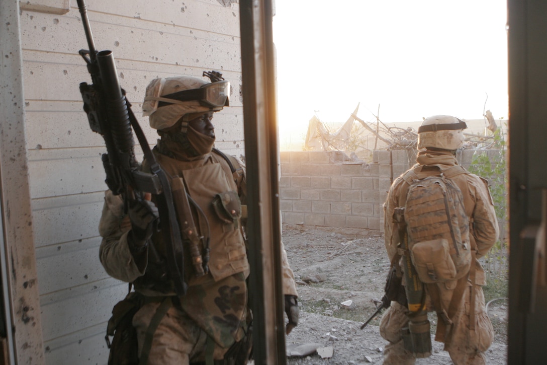 UBAYDI, Iraq ? (pictured left) A native of Dakar, Senegal, Lance Cpl. Pascal R. Cisse, an infantryman assigned to 3rd Platoon, Company E, 2nd Battalion, 1st Marine Regiment, temporarily assigned to Regimental Combat Team 2, moves from house to house searching for insurgents and weapons during combat operations here Nov. 14.  The 27 year old, who speaks five languages, came to United States and volunteered for the Marine Corps three weeks after his arrival there.