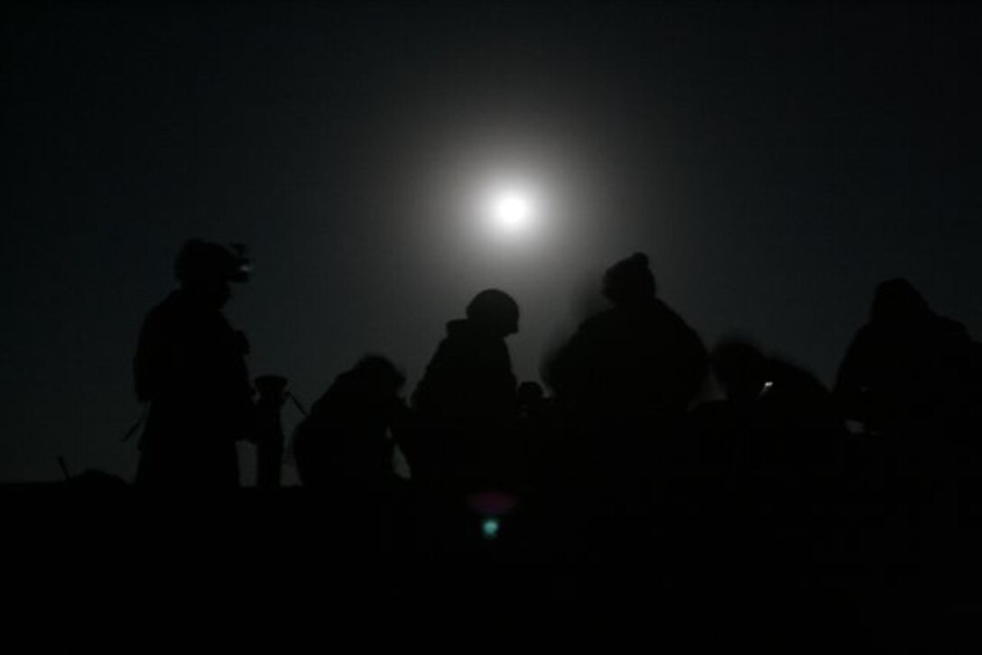 UBAYDI, Iraq ? With a full moon shining in the night sky, Marines rise to pack their gear and put on their equipment at an assembly area before moving towards Ubaydi during the early morning hours of Nov. 14. The Marines, assigned to 3rd Platoon, Company E, 2nd Battalion, 1st Marine Regiment, participated in Operation Steel Curtain against insurgents here and within other border towns on the Lower Euphrates River Valley recently.