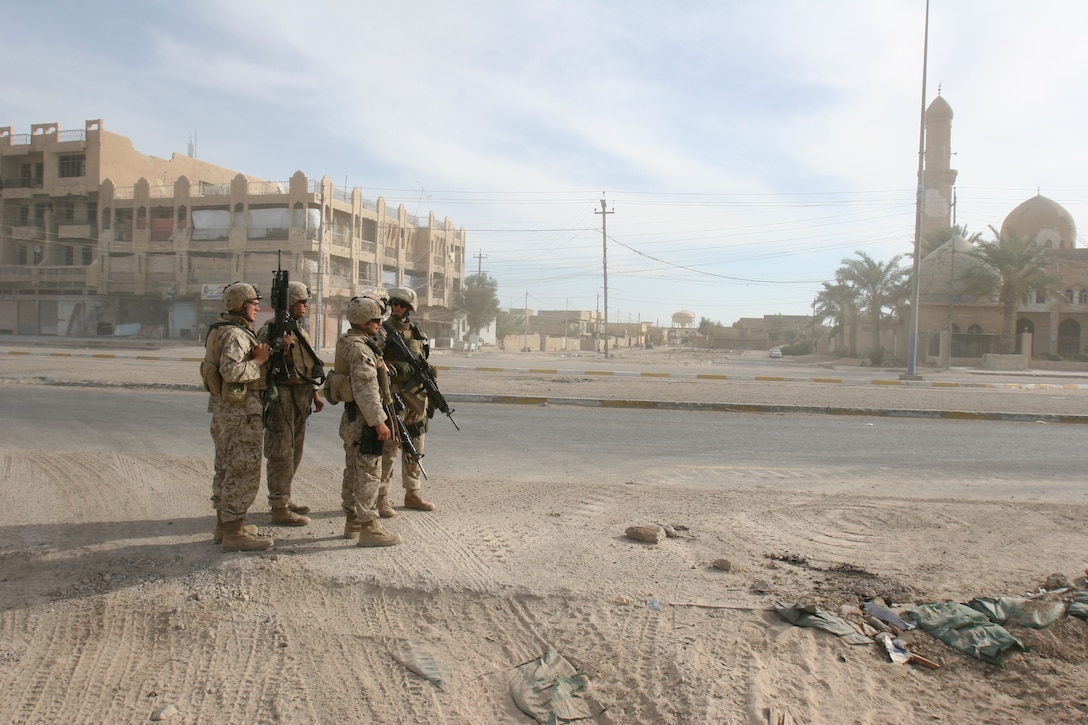 Second Lieutenant Ernest P. Abelson gives orders to Cpl. Chris W. Adair and other squad members after Iraqi Security Forces report a possible IED on the side of a road in Fallujah.