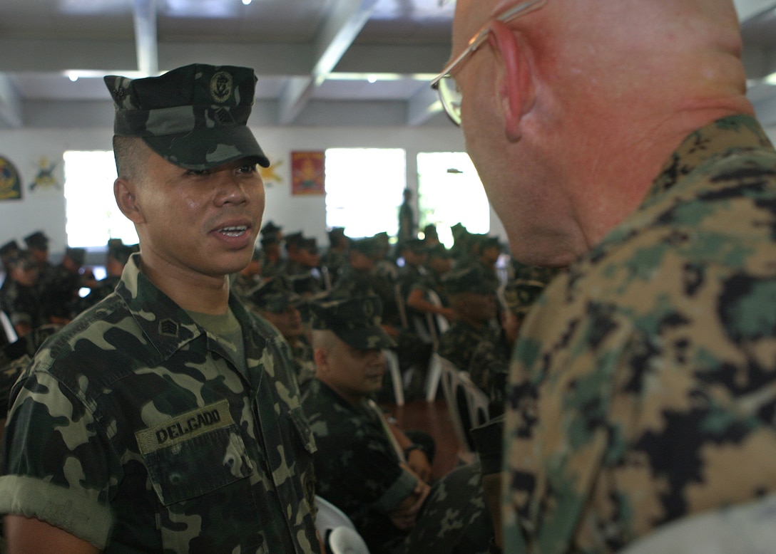 051014-M-9336C-001 MANILA, Republic of the Philippines - U.S. Marine Sgt. Maj. James R. McKay greets Philippine Marine Sgt. Jonathan S. Delgado during the opening ceremony for a bilateral training evolution taking place in the Philippines. The training includes two exercises, Talon Vision and Amphibious Landing Exercises 2006, which are designed to improve interoperability, increase readiness and continue professional relationships between the U.S. and Philippine Armed Forces. McKay is the 31st Marine Expeditionary Unit sergeant major and Delgado is an infantryman with Marine Battalion Landing Team-2, Philippine Marine Corps. (Official U.S. Marine Corps photo by Sgt. Mike Camacho)(released)