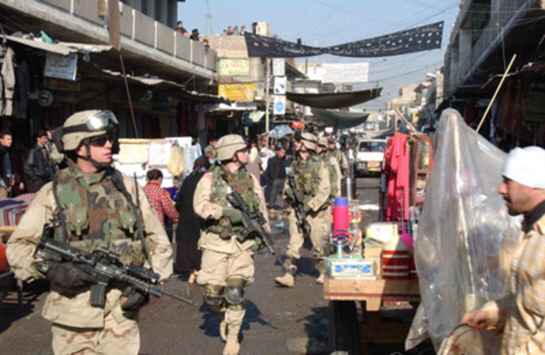 U.S. Army soldiers walk through a market in the Al Sudeek district during a dismounted patrol in Mosul, Iraq, on Jan. 9, 2005. The soldiers are assigned to Bravo Company, 2nd Battalion, 325th Parachute Infantry Regiment, attached to Task Force Tacoma. 