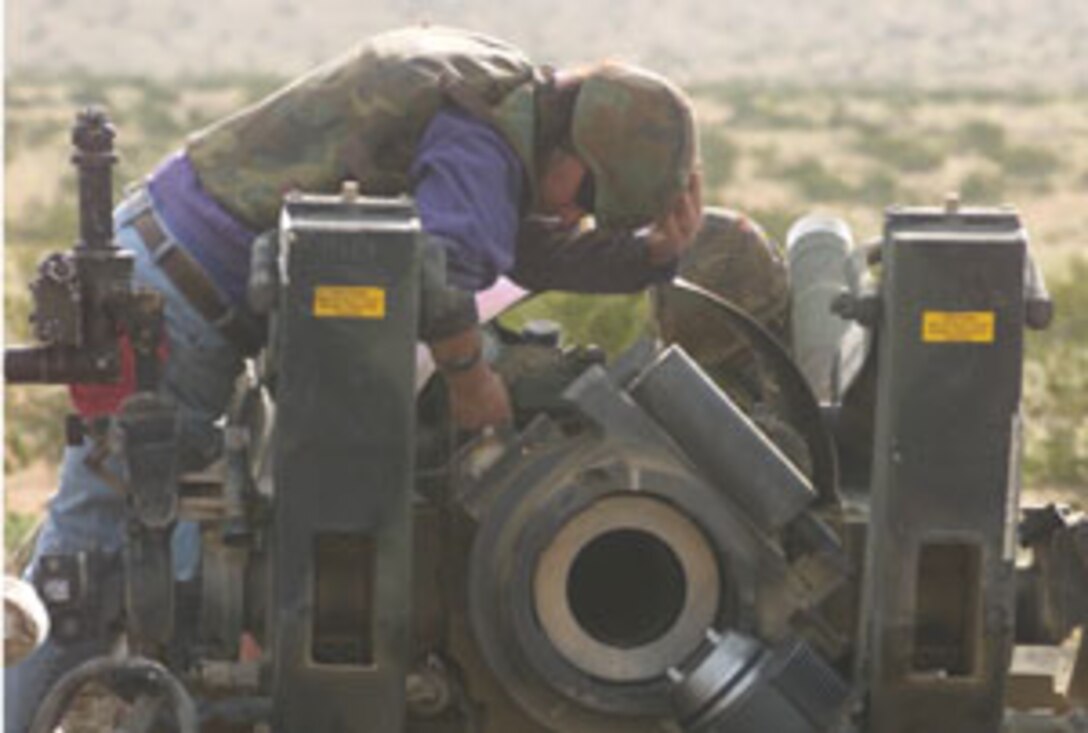 Christopher Benavidez, artillery repairer, checks the pressure of the nitrogen in the recoil mechanism.