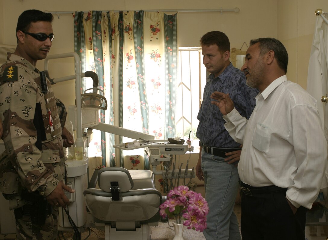FALLUJAH, Iraq - A captain with the Iraqi Security Forces speaks with medical personnel inside a clinic here May 15 as he inspects their dentistry equipment.  ISF worked alongside American personnel to speak with local doctors and clinic administrators to find out what supplies they needed, and how military personnel can help improve Iraq's medical system.