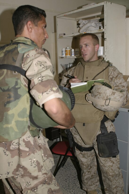 FALLUJAH, Iraq - Navy Lt. Brendon Drew, 1st Battalion, 6th Marine Regiment's surgeon, takes notes as he speaks with an Iraqi doctor and physicians at a local clinic here May 15.  American personnel worked alongside Iraqi Security Forces to speak with local doctors and clinic administrators to find out what supplies they needed, and how military personnel can help improve Iraq's medical system.