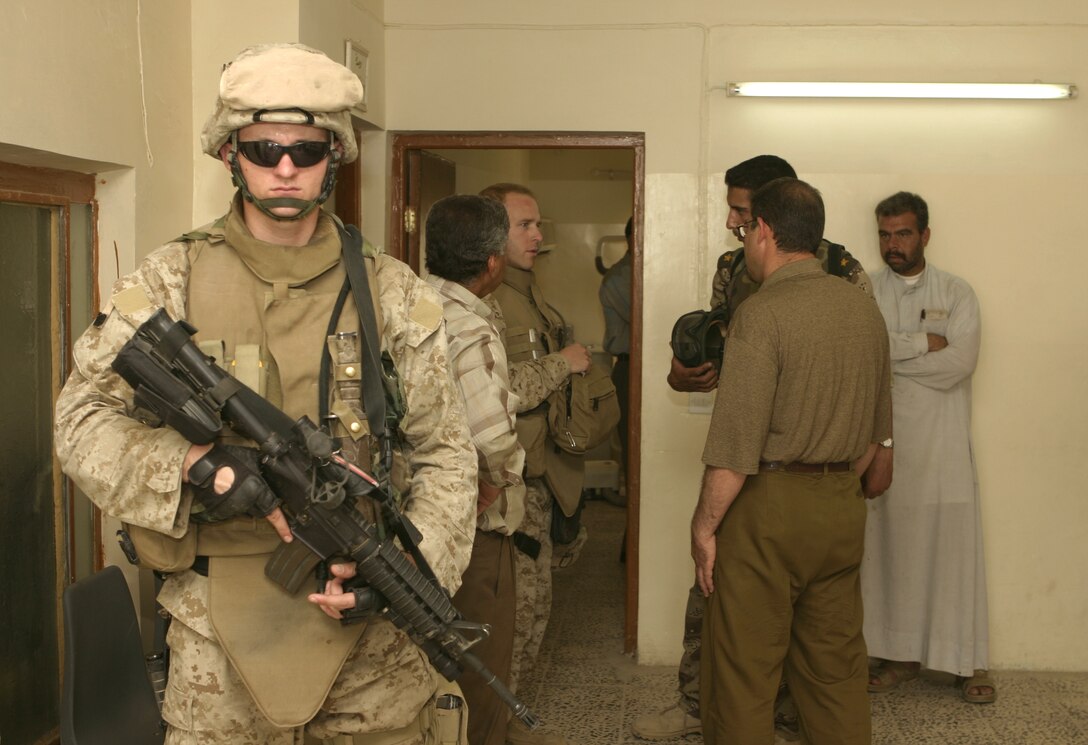 FALLUJAH, Iraq - Cpl. Joshua Hazelwood, 3rd squad leader, 2nd Platoon, Company B, 1st Battalion, 6th Marine Regiment, provides security for U.S. and Iraqi medical personnel inside a clinic here May 15.  Company B worked alongside Iraqi Security Forces to speak with local doctors and clinic administrators to find out what supplies they needed, and how military personnel can help improve Iraq's medical system.