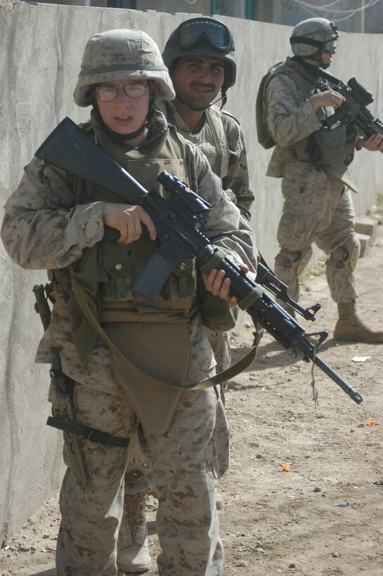 AR RAMADI, Iraq (May 16, 2005) - Lance Cpl. Aaron C. Cardenas, a rifleman with 2nd Squad, 3rd Platoon, Company A, 1st Battalion, 5th Marine Regiment, is joined by a New Iraqi Army (NIA) soldier during a mission in the city here. The 21-year-old from Monterey Park, Calif., and his fellow warriors with 3rd Platoon conducted a cordon and search mission of a neighborhood with 15 NIA soldiers. The three-hour joint-operation was geared toward keeping a military presence in area and establishing a positive relationship between Iraqi civilians and members of their own military. The Marines and their Iraqi counterparts executed the mission without incident. Photo by Cpl. Tom Sloan