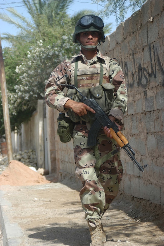 AR RAMADI, Iraq (May 16, 2005) - A New Iraqi Army (NIA) soldier walks along a street in the city here during a mission with Marines with 3rd Platoon, Company A, 1st Battalion, 5th Marine Regiment. Fifteen NIA soldiers accompanied Marines with 3rd Platoon and, together, conducted a cordon and search mission of a neighborhood. The three-hour joint-operation was geared toward keeping a military presence in area and establishing a positive relationship between Iraqi civilians and members of their own military. The Marines and their Iraqi counterparts executed the mission without incident. Photo by Cpl. Tom Sloan