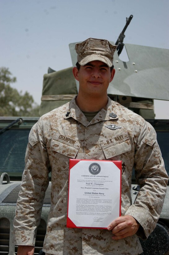 CAMP HURRICANE POINT Ar Ramadi, Iraq (July 15, 2005) - Paul W. Champion, 25, of Iron Mountain, Mich., was meritoriously promoted to the rank of petty officer 2nd class during a ceremony here July 15. The hospitalman and the senior line corpsman for Company A, 1st Battalion, 5th Marine Regiment, was one of only two Sailors selected to pin on the rank meritoriously while serving in combat, under the Navy's newly mandated Combat Meritorious Advancement Program. Champion has been a corpsman for three and a half years and has served with 1st Battalion, 5th Marines for two years. He received a Navy Commendation medal with combat V device for his actions in Fallujah on April 7, 2004 with Camp Pendleton, Calif., based infantry battalion. Champion graduated from Kingsford High School in 1999 and has an Associates degree in Criminal Justice for Northern Michigan University. Photo by: Cpl. Tom Sloan