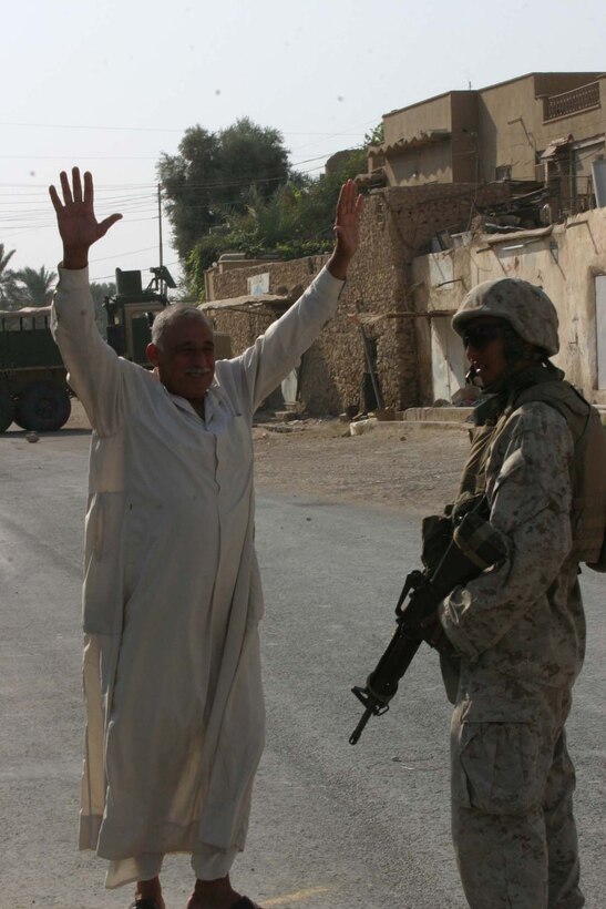 HADITHA, Iraq (Oct. 15, 2005)  - escorts a citizen to be searched at the polling site here Oct. 15. Ybarra, and other Marines with 3rd Battalion, 1st Marine Regiment, assisted Iraqi Security Forces providing security for elections as more than citizens cast their vote. (Official Marine Corps photo by Cpl. Adam C. Schnell)