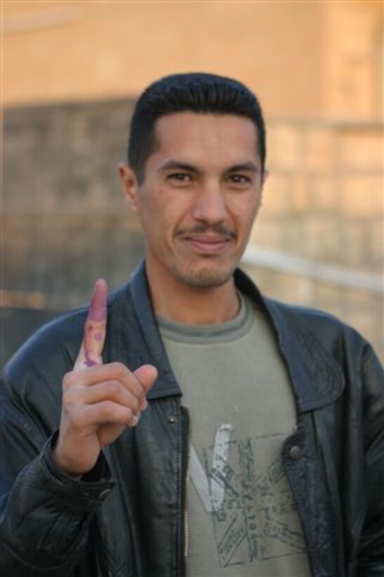 HADITHA, Iraq ? An Iraqi man shows his ink-stained finger after casting his vote here Dec. 15. The more than 15,000 people still came to the polling sites after threats to their lives by insurgents if they voted.