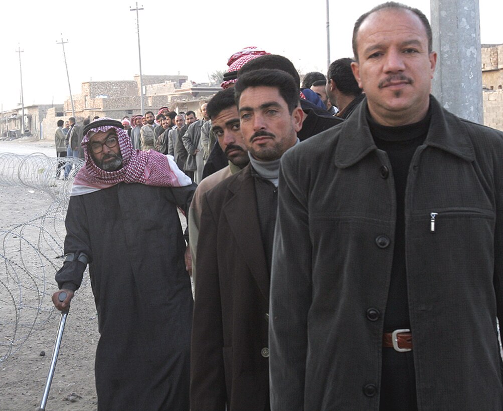 Iraqi men from Husaybah, Iraq, wait in line to vote for a permanent Iraqi government Dec. 15.