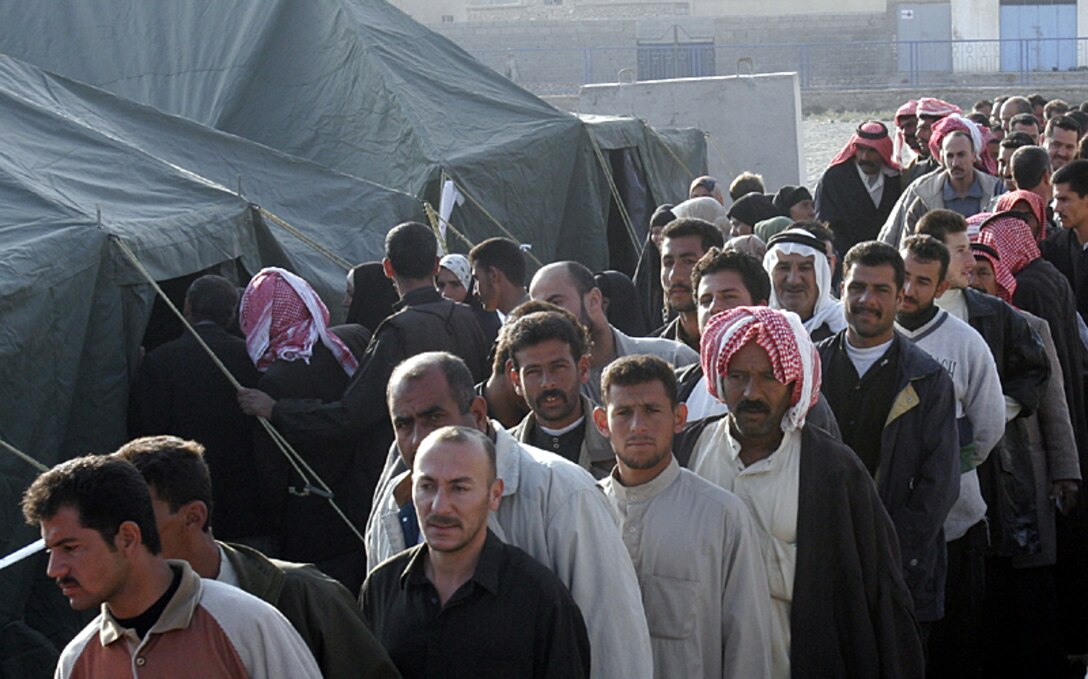 Iraqi men from Husaybah, Iraq, wait in line to vote for a permanent Iraqi government Dec. 15.
