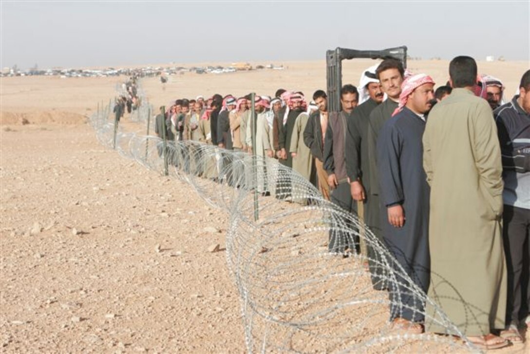 RUTBAH, Iraq ? Local Iraqi citizens line up to vote at a polling site here Dec. 15. In open defiance toward radical Islamist insurgents, tens of thousands of Iraqis came out to the polls across the Sunni-dominated, Al Anbar province in Iraq, Dec. 15. In Rutbah, Iraqi troops provided security at polling sites with U.S. Marines from Task Force Highlander, Regimental Combat Team 2, standing by in case of any violent interference of the democratic process.