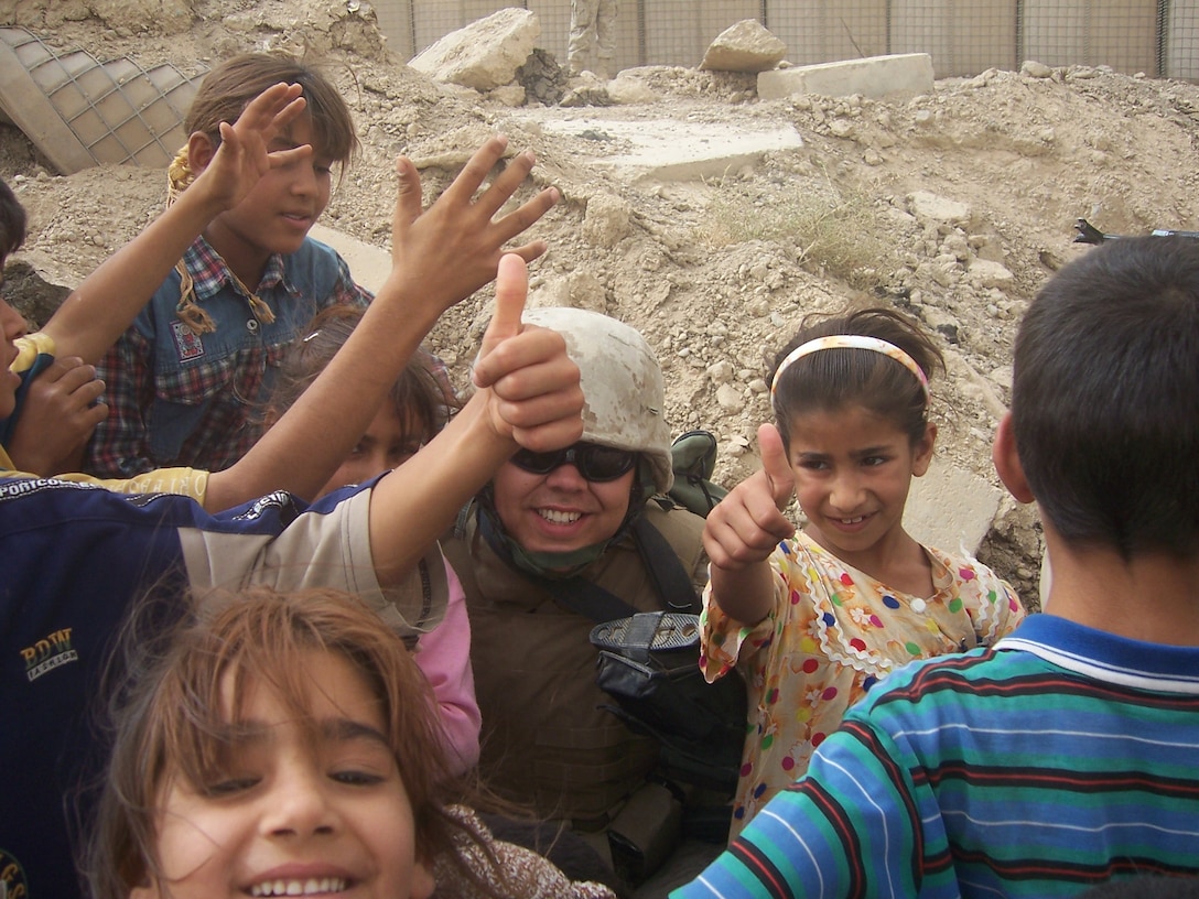 Lance Cpl. Champion of Regimental Combat team 8, hands out toys to local children of Fallujah during his weekly trip out to the city.   Each week, Items donated from friends, family, and organizations from the US, are handed out to the children as part of RCT 8?s motto of  ?Winning Hearts and Minds.?