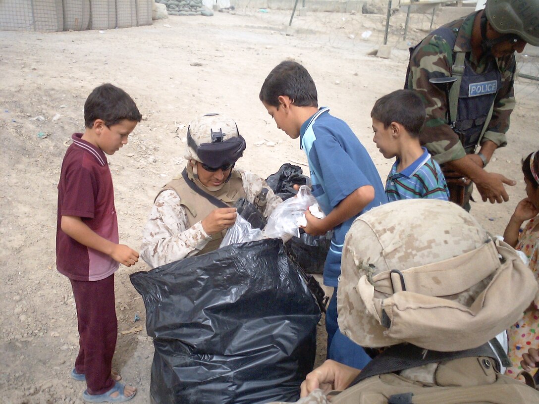 Staff Sgt. Hernandez Garcia of Regimental Combat Team 8, 3rd Recon BN, helps pass out toys 14 July, 2005.  The toy distribution  is a weekly event as part of the mission for RCT 8 to ?Win the Hearts and Minds? of the Iraqi people.