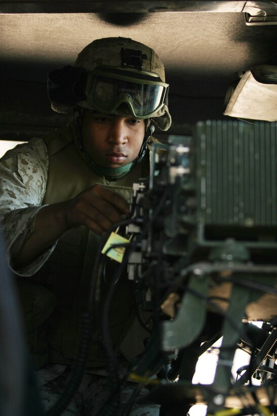 CAMP BLUE DIAMOND, AR RAMADI, Iraq -- Corporal Kelvin Brodie, a 21-year-old Raleigh, N.C. native, performs a radio check inside his High Mobility Multi-Wheeled Vehicle, March 16.  Brodie is the personal driver for 2d Marine Division, Headquarters Battalion's commanding officer.  U.S. Marine Corps photo by Sgt. Stephen D'Alessio (RELEASED)