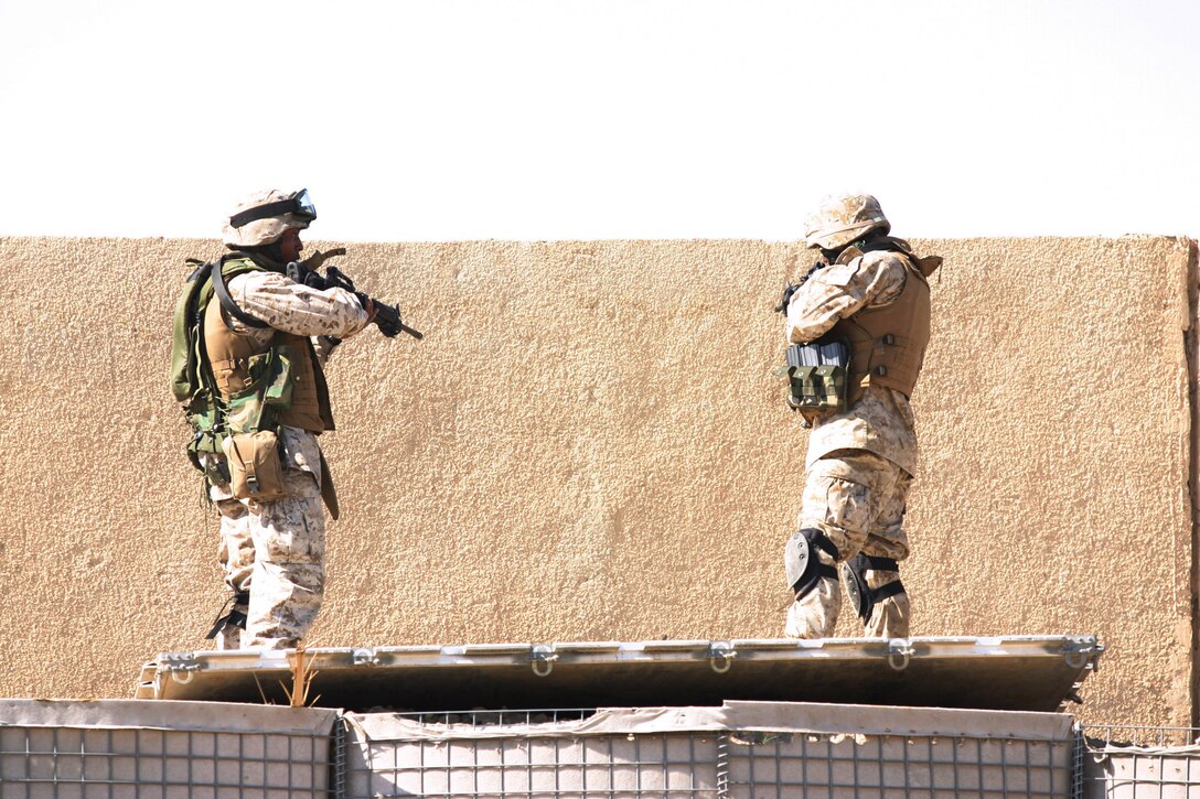 CAMP BLUE DIAMOND, AR RAMADI, Iraq -- (Left) Corporal Marquette Diggs, a 21-year-old China Grove, N.C. native and 2001 South Rowan High School graduate, secures the outer perimeter of the camp during a drill for the Ready React Team, March 16.  The random drills simulate an insurgent infiltration and the Marines react to various situations.  U.S. Marine Corps photo by Sgt. Stephen D'Alessio (RELEASED)