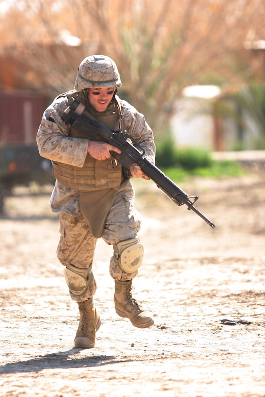 CAMP BLUE DIAMOND, AR RAMADI, Iraq -- Corporal Brandan Beaird, a 31-year-old Sikeston, Mo. native rushes to cover his team members during one of the camp's Ready React Team drills, March 16.  The random drills simulate an insurgent infiltration and the Marines react to various situations.  U.S. Marine Corps photo by Sgt. Stephen D'Alessio (RELEASED)