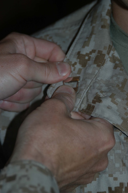 CAMP HURRICANE POINT, Ar Ramadi, Iraq (April 16, 2005) - The commanding officer for 1st Battalion, 5th Marine Regiment, Lt. Col. Eric M. Smith, pins the rank insignia of Navy lieutenant on Mike A. Quaresimo, information operations officer, Information Operation, Headquarters and Service Company, 1st Battalion, 5th Marines, during a promotion ceremony here. The 32-year-old from Poughkeepsie, N.Y., was promoted from lieutenant junior grade to the rank of Navy lieutenant. Quaresimo volunteered to accompany warriors with 1st Battalion, 5th Marines on their deployment to Ar Ramadi in support of Operation Iraqi Freedom. Photo by Cpl. Tom Sloan