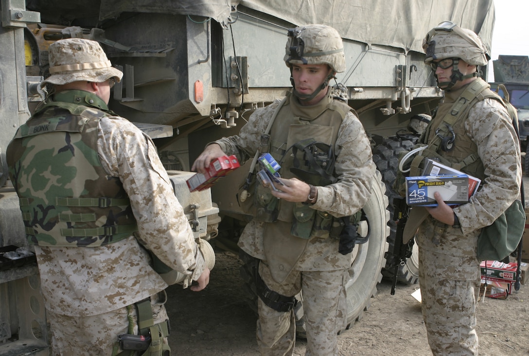 FALLUJAH, Iraq - Marines with Company B, 1st Battalion, 6th Marine Regiment, wait in line outside their base of operations here April 19 to pay for snacks they purchased from the 'exchange on wheels' store.  The store is one element of the 'XO's Road Show,' a Headquarters and Service Company convoy that travels once a week to the battalion's infantry companies' bases in Fallujah to offer the grunts services such as motor transport and communications equipment repair, religious services, and administrative and legal support.